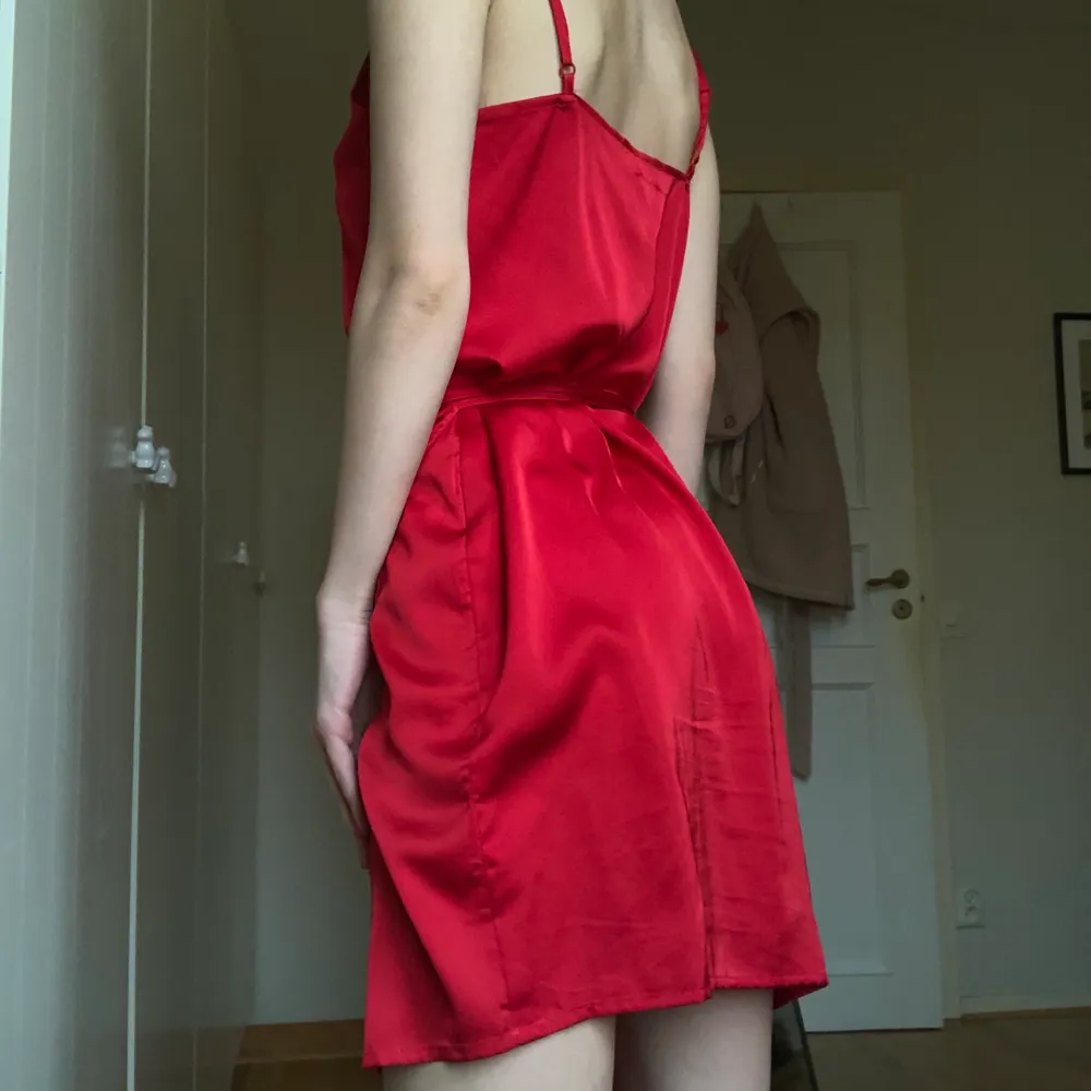 En klänning i wrap stil med band att knyta i midjan. Justerbara axelband. Röd satin tyg. Knappt använd. Storlek 36. Frakt 62 kr eller kan mötas i Malmö #nakd #klänning #röd #satin. Klänningar.