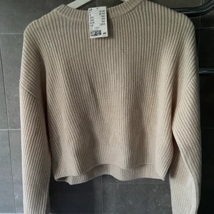 Beige stickad tröja - Jättefin beige stickad tröja. Extremt fint skick, helt oanvänd, till och med prislappen kvar! Lite kroppad tröja i en sjukt fin beige färg!