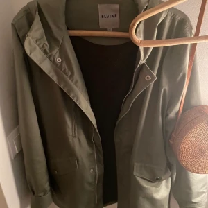 Elvine vårjacka - Klassisk vår/höstjacka för dam fr  Elvine i stl M. Grön/grågrön. Använd några ggr, men tycker den för mig är lite tight runt höft. Perfekt till våren nu!