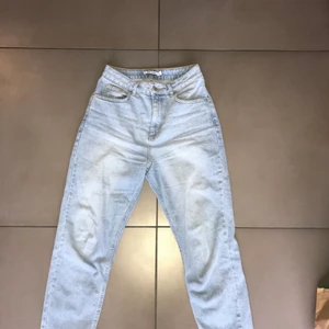 Mom jeans NA-KD - Ljusblåa mom jeans från NA-KD i fint skick. Säljes pga var för stora. Ursprungspris 399kr, säljes för 100kr. Kan mötas upp inom Helsingborg, annars betalar köparen för frakten.