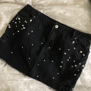 svart lowwaist jeanskjol - säljer denhär söta korta svarta jeanskjolen med fina pärlor, paljetter å revor 💓 tyvärr är lappen avklippt men skulle säga storlek L (40/42-ish) 💖 nyskick!!