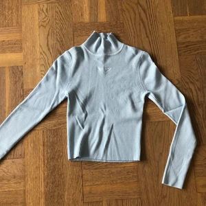 Ljusblå polotröja  - Ljusblå ribbad polotröja. Säljer då den inte kommer till användning. Köparen står för frakt.