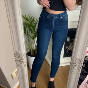 NA-KD - Dö snygga high waist jeans från NA-KD med rippade kanter nere vid anklarna. Säljer för de tyvärr inte kommer till användning längre. Använt några gånger bara så de är felfria och hela!