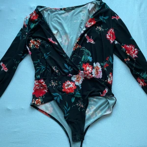 Topp - En blommig body ifrån Nelly i storlek s