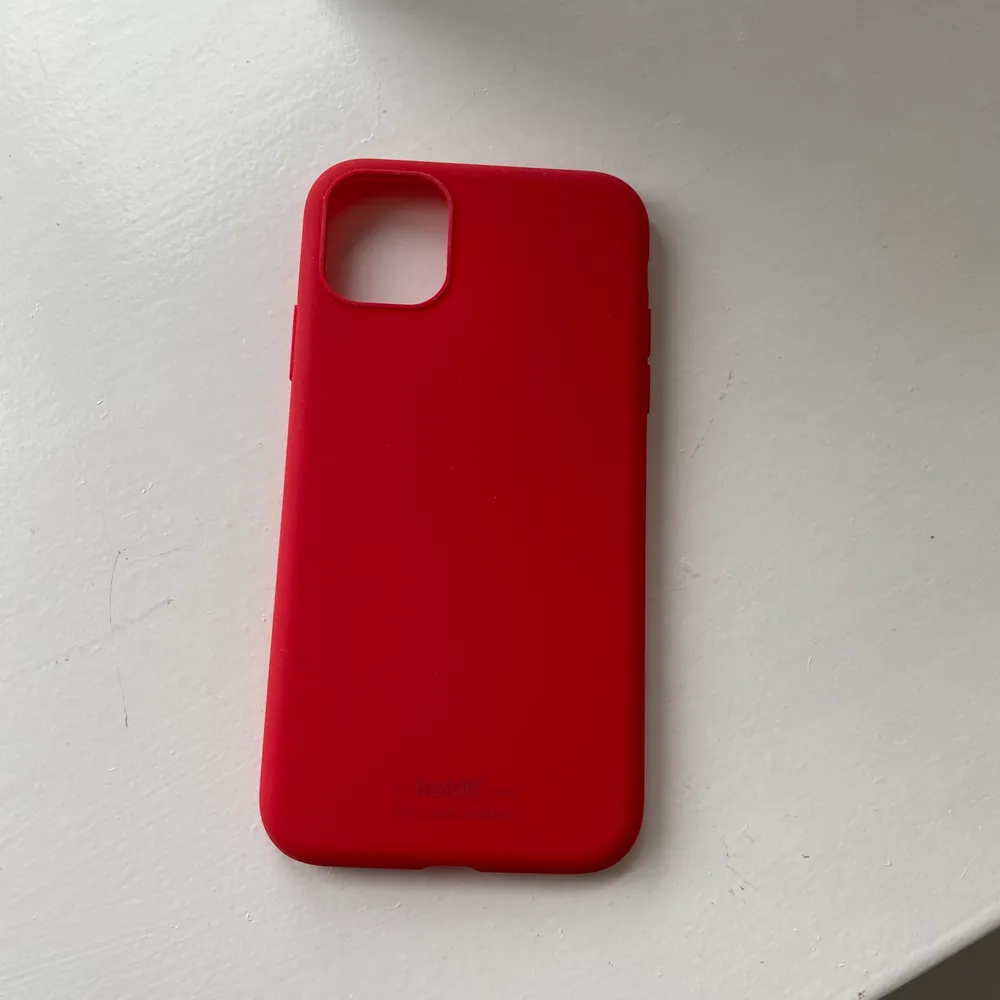 Rött skal från holdit i silikonmaterial, oanvänt då jag köpte fel storlek. Passar till iPhone 11 pro, frakt ingår💜💜. Accessoarer.