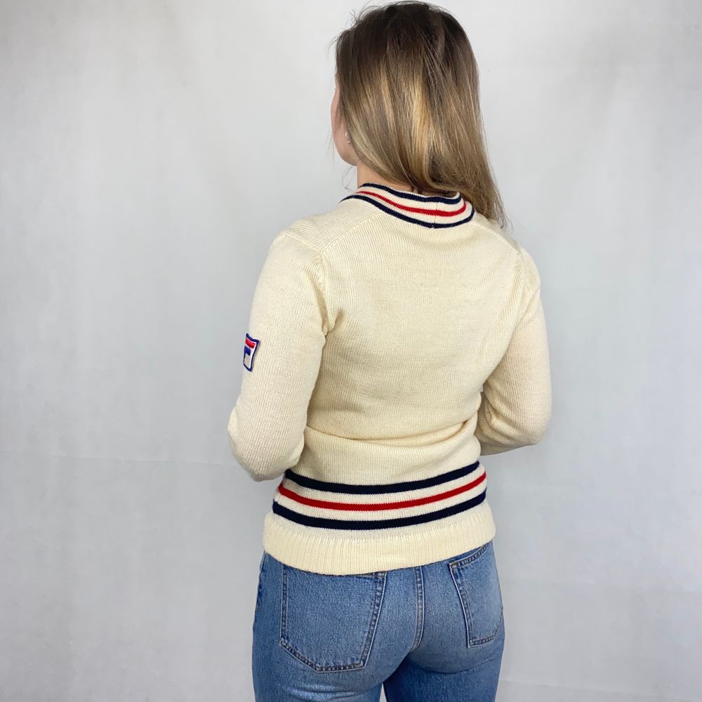 Vintage crème white sweater från FILA. Pure Lana vergine. Några små tecken på användning, ett hål i mitten som har sytts ihop. Finns några ljusa fläckar. Annars i ok skick! Kliar lite så rekommenderar att a ha en tunn långärmad under. Modellen använder storlek S och är 169cm för referens. Axeln till axeln 43cm, längd 66cm, byst bredd 47cm och ärm längd 61cm. Spårbar frakt på 66kr är inräknad i priset och SafePay tar 10% av betalningen. . Stickat.