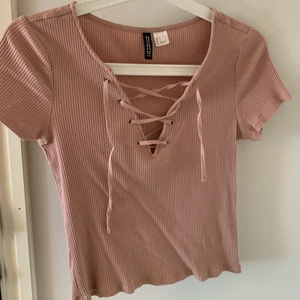 Ribbad T-shirt med snörning - Från H&M. Fint skick. Frakt tillkommer 
