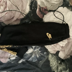 Nike - Nike mjukis byxor med guld detaljer 