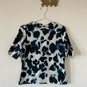 T-shirt/croptop från Monki  - Mönstrad topp från Monki. Kortare modell som passar fint med höga byxor eller kjol. Strl m. Fint skick.
