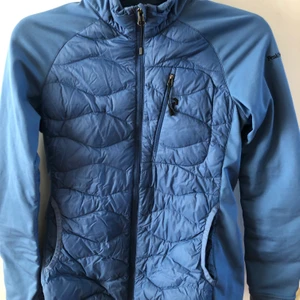Jacka, Peak performance - Lättviktsdunjacka fr Peak. Fungerar som mellanlager på vintern. Sparsamt använd. Inköpt -19. Stretch i armar (ej vadd där). Fin blå färg. 