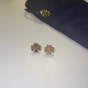 Tory Burch  - Tory Burch klassiska örhängen med klassiska monogrammet i guld. Näst intill oanvända, inköpte för ca 1 år sedan i USA. Pris: 300kr + frakt.  Nypris 999kr