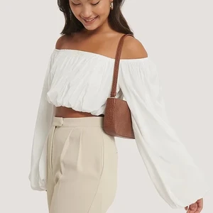 Nakd Baguette Bag brown - Baguette väska från Na-kd, köpte i juni 2020. Fint skick, inget slitage. Säljer pga kommer inte till användning. Skinimitation med gulddetaljer och svagt ”ormliknande” mönster (se bild). 