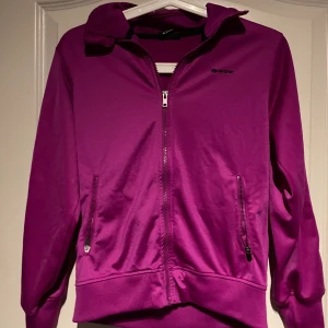 Plommonlila träningsjacka SOC - Lila träningsjacka från SOC i bra skick. Köparen står själv för frakten 