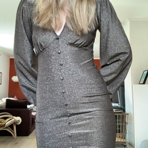 Glittrig midklänning - Glittrig midklänning i guldsilverfärg i Stl 36 från ASOS egna märke. Aldrig använd, lappen kvar! Skickas med spårbar frakt mot betalning :)