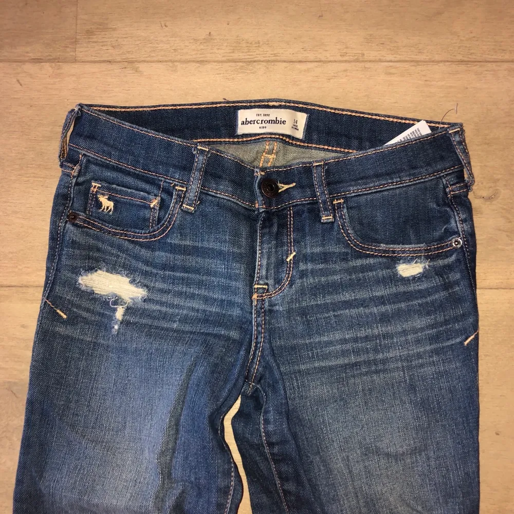 Säljer low-waisted jeans från abercrombie kids. Fina slitningar och låg midja. Straight modell, något tajta men raka vid ankeln. Endast använda ett fåtal gånger. Skriv privat för fler bilder💜. Jeans & Byxor.