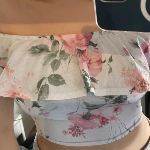 Blommig topp - Säljer denna fina blommiga off shoulder topp. Från Nelly trend, storleken S. Säljer för 20kr+frakt