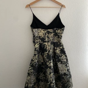 Snygg klänning  - Cocktail klänning i mörk grå med guld detaljer. Jag har använt bara en gång till ett bröllop. 