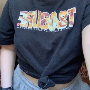 T-shirt  - Cool svart T-shirt i storlek L. Den är i bra skick och har en massa tryck på sig om surfing. 