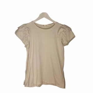 14  - En vanlig vit t-shirt med volang på ärmarna 