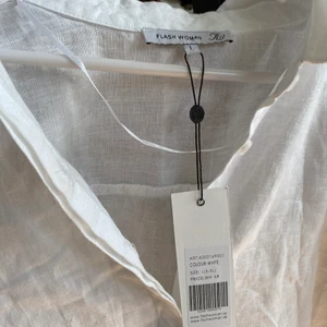 Blus - Vit blus i linne. Snygg till höga byxor, ha öppen över något linne eller över bikinin på stranden. 