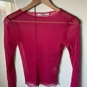 Mesh tröja - Rosa glittrig mesh tröja den nakd. Använd en gång och säljs då den inte kommer till användning. Frakten går förmodligen att få billigare.