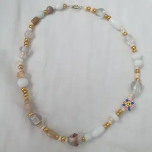 Vitt/ guldigt halsband med olika pärlor. Går att knäppa. Längd: 40 cm
