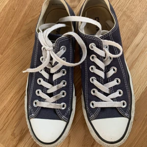Skor - blå converse - Låga, blå converse i storlek 37 (4,5). I använt skick men inte trasiga på utsidan, endast en liten bristning i tyget på insidan vid hälen (se bild 3). Pris exklusive frakt, osäkert på vad den kostar men jag kan anpassa lite om den blir dyr. 
