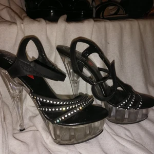 Luichiny högklackade strl 36 -  Luichiny högklackade. Svarta med strass stenar och genomskinlig plastfot. Använda endast en gång. Köparen betalar frakten. 