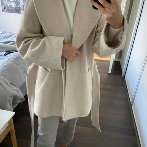 Ullkappa från hm  - Ljus beige kort kappa med skärp. Storlek 34. 65% ull. Oanvänd med lapp kvar 