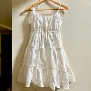 Vit, kort klänningen  - Klänningen är kort och slutar precis över knäna, möjligtvis lite längre upp. Har aldrig använts, ändast testad. Original priset är 200kr