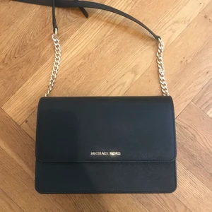 Michael Kors Daniela Gusset crossbody axelremsväska  - Svart Michael kors väska i skinn med tyginrede.   Väskan är som ny då jag bara använt den 2ggr, så de är i väldigt fint skick!   Nypris: 2195kr