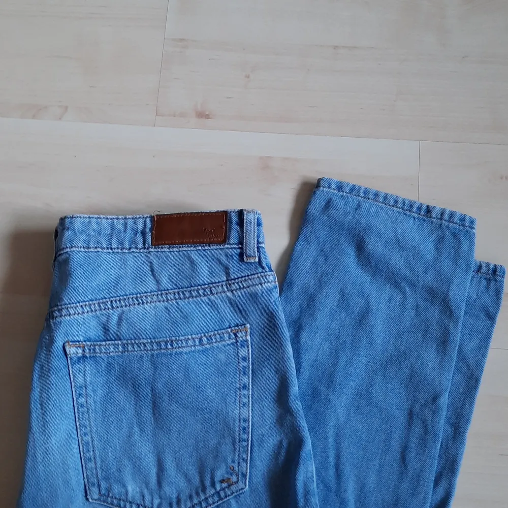 Ett par blå jeans, Never Denim, i storlek M. Det är en design med hål på vänster knä. Byxan smalnar av vid ankeln. Använda men i fint skicka, fick dem men aldrig själv använt dem så säljer. Pris: 80 + frakt. Jeans & Byxor.