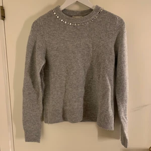 Grå stickad tröja - Detta är en fin grå stickad tröja med diamanter runt kragen. Den är använd men i väldigt bra skick. Det är storlek xs men passar s också.