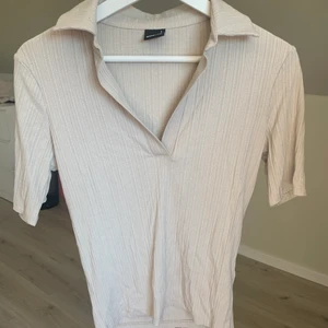 Beige t-shirt  - Supersöt ribbad t-shirt från Gina Tricot, använd vid ett tillfälle. Perfekt till vardagstillfällen men även lite finare tillfällen.