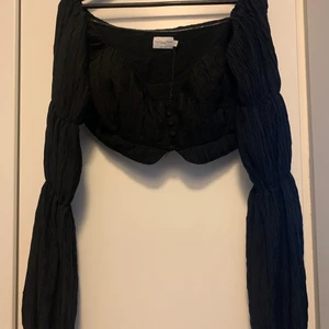 Angelica Blick X NA-KD - Kort blus från NA-KD X Angelica Blick! Den täcker endast brösten och är liten i passform! Det är en storlek L men sitter som en M