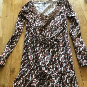 Blommig klänning 32/34 - Sommarklänning blommig och ett rep runt midjan dessutom broderad vid halsen.