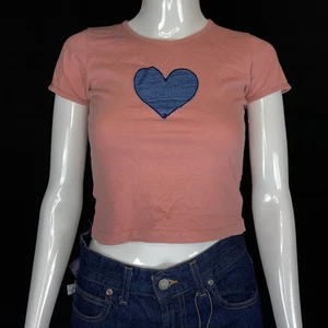 Topp  - Söt baby tee i okej skick. Några utstretchade sömmar, nopprig runt om. Inga hål eller fläckar. Jeanstyg format till ett hjärta i mitten! Från Impuls, storlek XS.   Mått -   Axel till axel 29cm, Ärmlängd 13cm, Bystbredd 33,5cm, Midjebredd 32cm.