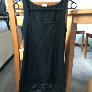 Svart linne med spetskant storlek S - Skönt linne i lite längre modell. Supersnygg spets längst ner. 