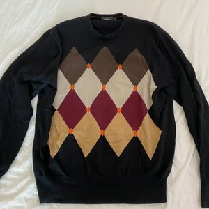rutig stickad tröja - svart stickad tröja med rutor. tröjan är i väldigt bra skick och säljer för att den inte används så ofta. det står storlek XL men skulle säga att den är mindre, M/L