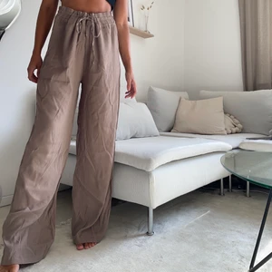 Luftiga Bruna Byxor - strl: M  - Helt nya byxor som aldrig använts pga köp av fel storlek. De är av materialet viskos och är därav ”luftiga” och väldigt bekväma. Byxorna är i storlek Medium, men eftersom de har dragsko i midjan så kan man förmodligen ha dem även som storlek Small eller Large.