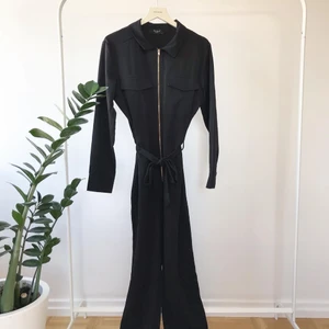 Svart jumpsuit  - Svart jumpsuit med krage och raka ben. Dragkedja fram och knyte i midjan💗 Aldrig använd.