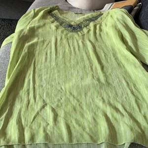 Tunika  - En ljusgrön tunika med pärlor som detaljer från foglie rosse i storlek L. Använd några antal gånger men är i fint skick. Köparen står för frakten.