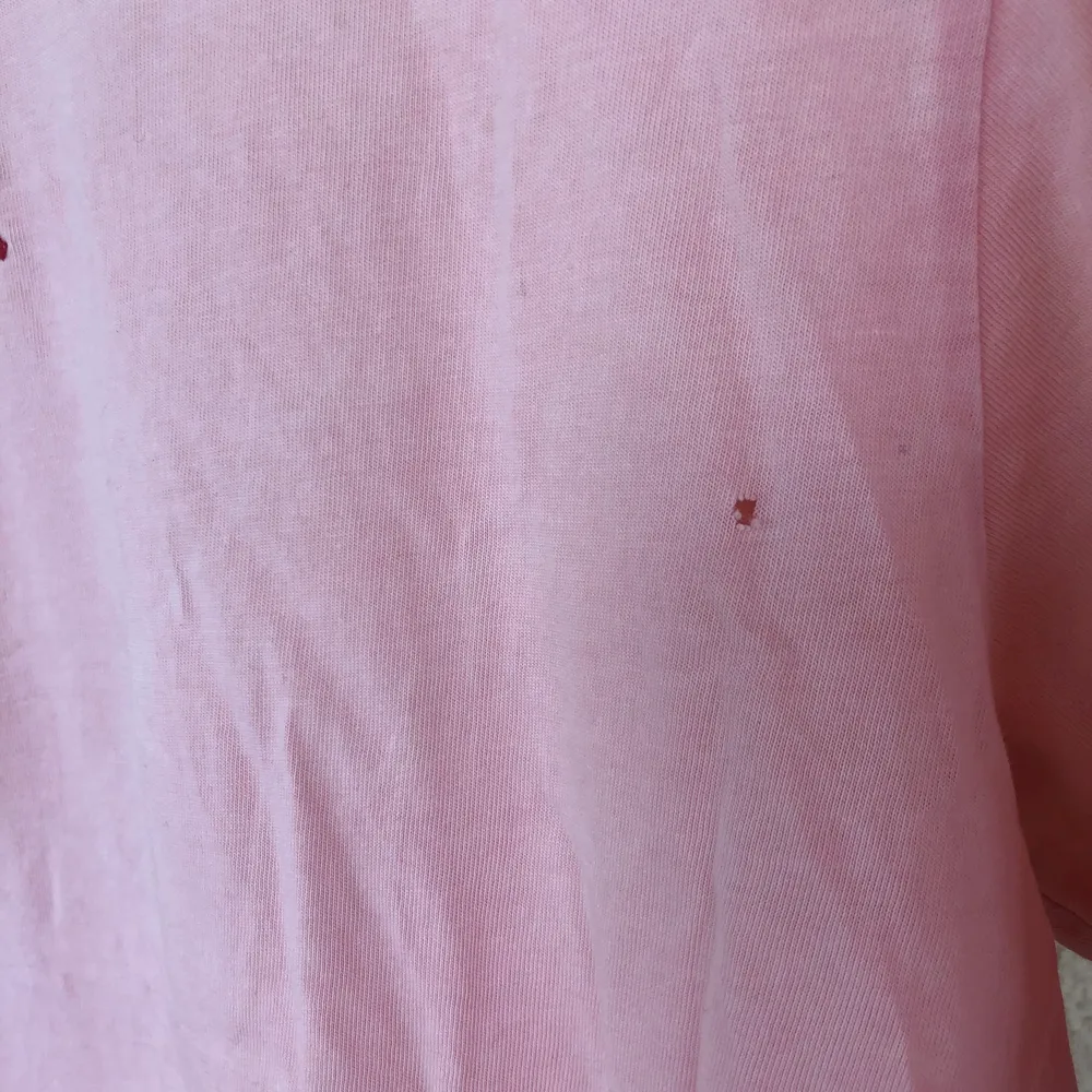 T-shirt från Urban Outfitters med rött tryck på ryggen och broderad text på framsidan. Det är ett litet hål på framsidan precis vid armhålan, men det går lätt att sy igen.   Tröjan är i storlek M men passar både på S och L beroende på hur man vill att den ska sitta.. T-shirts.