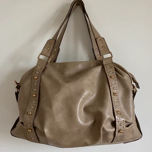 Beige axelväska - Väskan har jag haft i några år men dem senaste åren har den mest legat i min garderob. Som ni ser på baksidan har den lite skrapmärken och därmed har jag även sänkt priset lite. Annars är den helt fungerande och jättesnygg. Den passar till allt och har ett stort utrymme. Längre sidobana ingår. 