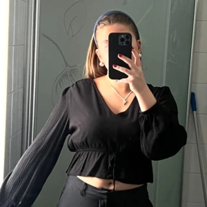 Svart blus - Säljer denna super sköna och snygga blus som passar perfekt nu i sommar och höst🌟 den är i storlek L men jag skulle säga att den sitter som en S. Den har super fina ballongärmar och är inte genomskinlig i matrialet