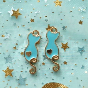 2st blå katt berlock, pärlor,  - Berlocker, hängsmycke, Motiv: katter  Färg: blå och guldfärgade baksida  Antal: 2st Skick: oanvända,  Går att använda till smyckestillverkning, tex sätta på halsband, armband eller göra örhängen av dem. 