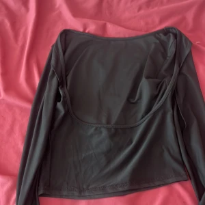 Svart långärmad topp - En svart långärmad topp med en enkel design. Toppen har en normal passform och är tillverkad i ett mjukt och bekvämt material.