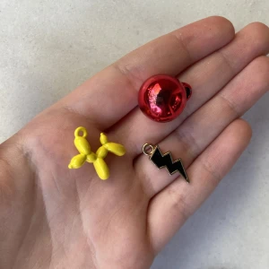 Tre fina berlocker  - Bra skick  En röd julkula En gul uppblåsbar hund Och en svart blixt med guld