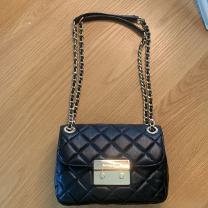 Svart läder väska Michael Kors - MK supersnygg svart handväska som ny. Mycket bra begagnat skick. 22 x 15 cm svart läder med summar
