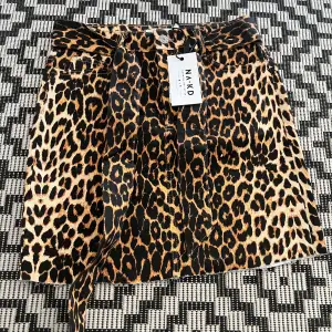 Den är aldrig använd och har fortfarande prislappen kvar. Snygg leopard kjol som är ganska lång men som man kan klippa av om man vill ha den kortare. Den har ett bälte som man kan ta bort också. Köpt från nakd för länge sen i storlek 36.